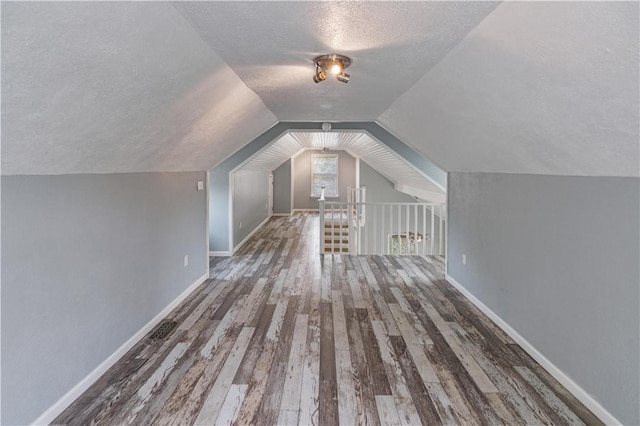 266 Lola Johnson Rd, Corpus Christi, TX 78418 - bonus room featuring a textured ceiling, wood finished floors, lofted ceiling, and baseboards