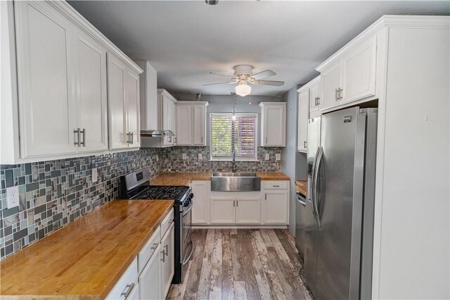 266 Lola Johnson Rd, Corpus Christi, TX 78418 - kitchen featuring wood counters, appliances with stainless steel finishes, a sink, ceiling fan, and white cabinets