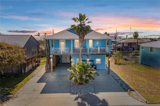 1035 Sea Secret St, Port Aransas, TX 78373 - coastal inspired home featuring driveway, stairs, an attached garage, a yard, and a carport