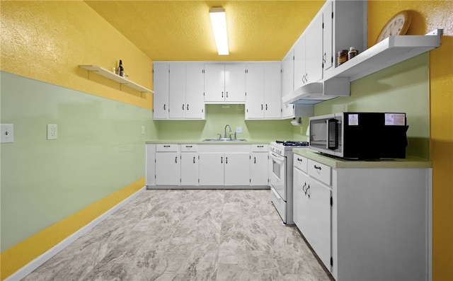 kitchen featuring white gas stove, white cabinets, a textured ceiling, and sink