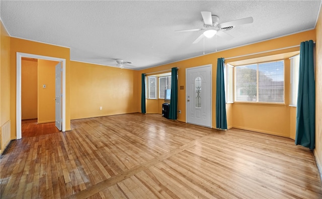 unfurnished living room with a textured ceiling, light hardwood / wood-style flooring, and ceiling fan