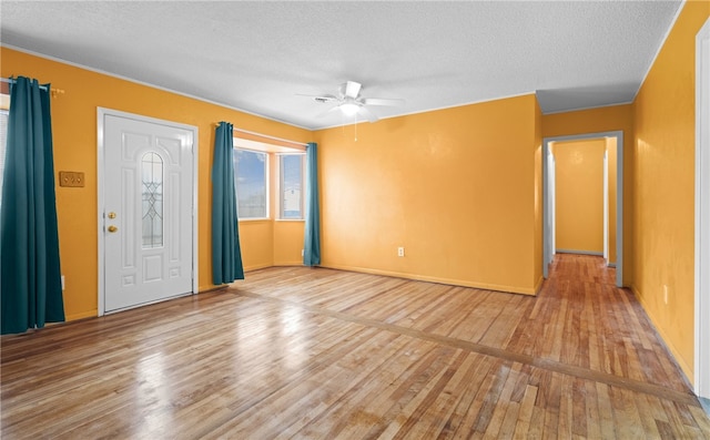 foyer entrance with ceiling fan, a textured ceiling, and light hardwood / wood-style flooring