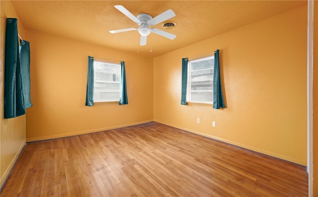 unfurnished room featuring ceiling fan, light hardwood / wood-style floors, and a textured ceiling