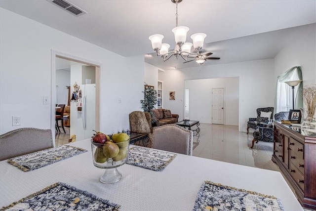 dining room with light wood-type flooring, an inviting chandelier, and visible vents