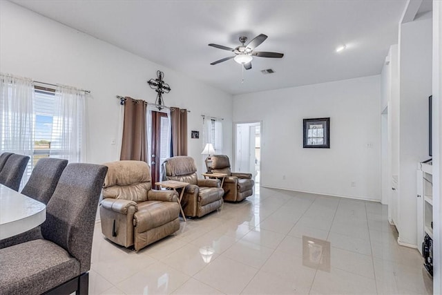 living area with light tile patterned flooring, a ceiling fan, and visible vents