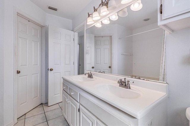 bathroom featuring tile patterned floors, double vanity, visible vents, and a sink