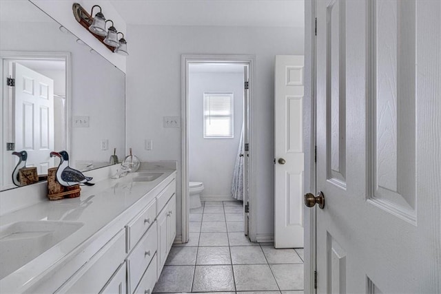 bathroom with tile patterned flooring, a sink, double vanity, and toilet