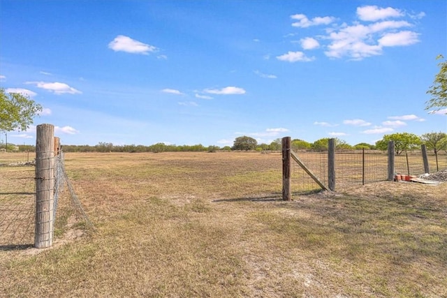 view of yard with a rural view and fence