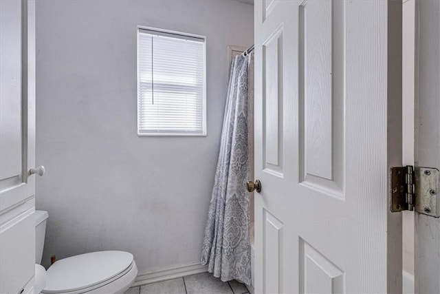 bathroom with tile patterned floors, curtained shower, and toilet