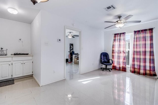 interior space with visible vents, baseboards, and a ceiling fan