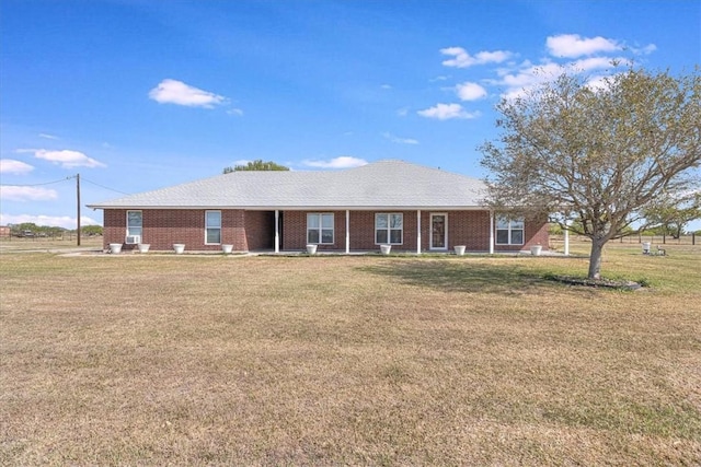 back of property with brick siding and a lawn
