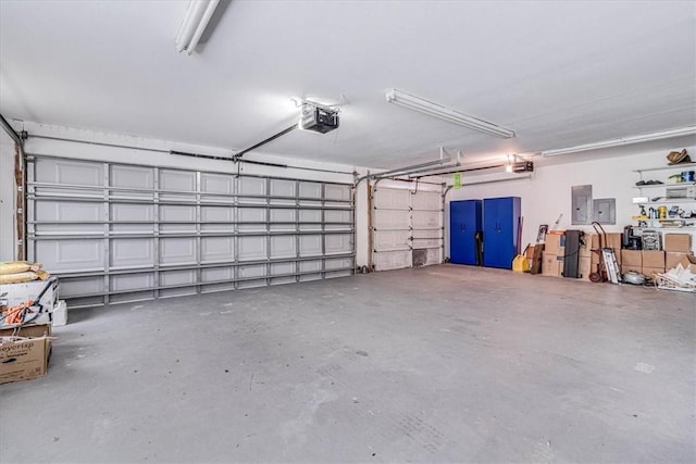 garage with electric panel and a garage door opener