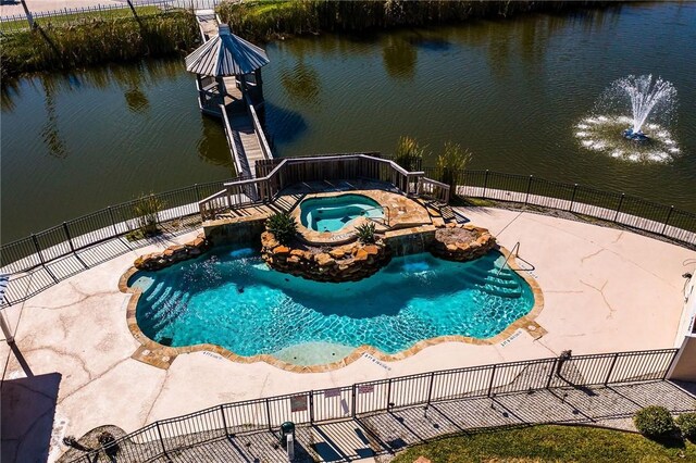 view of pool featuring an in ground hot tub and a water view