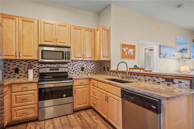 kitchen with sink, decorative backsplash, light brown cabinetry, and stainless steel appliances