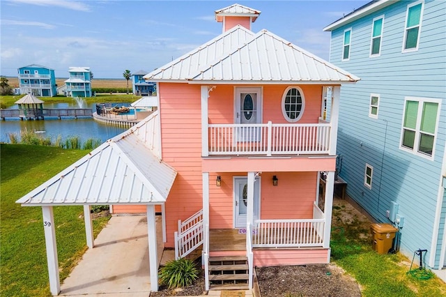 view of front of house with a balcony, a carport, a water view, and covered porch