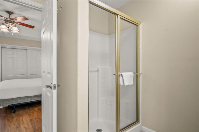 bathroom featuring a shower with shower door, ceiling fan, and hardwood / wood-style floors