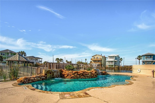 view of pool featuring pool water feature, a gazebo, and a patio