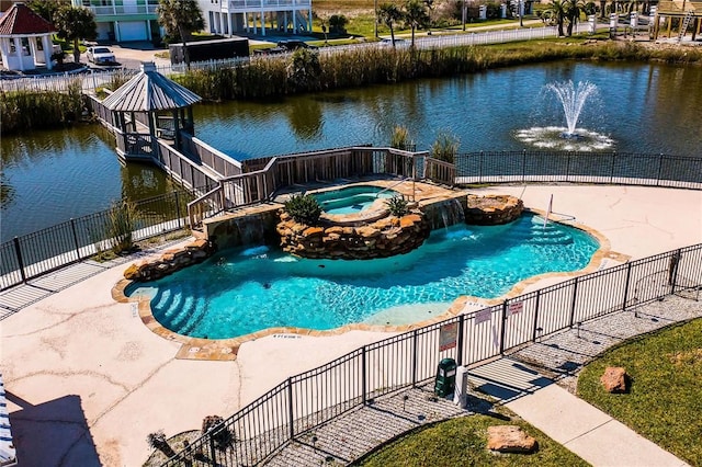 view of swimming pool featuring pool water feature, an in ground hot tub, and a water view