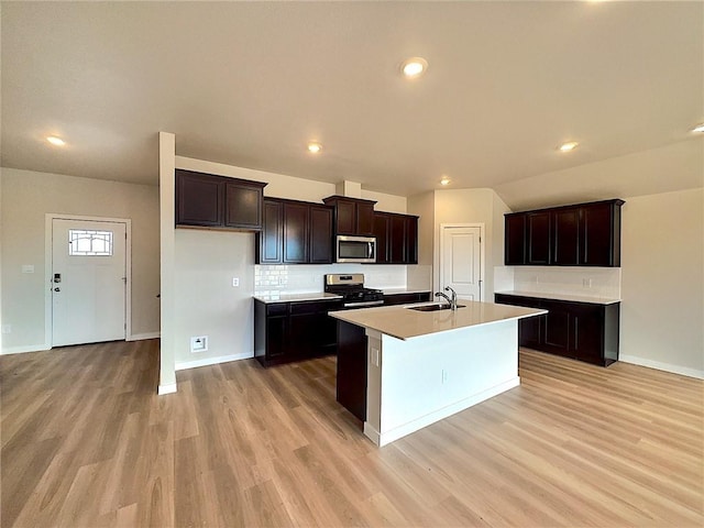 3405 Tanzanite Dr, Corpus Christi, TX 78414 - kitchen featuring stainless steel appliances, light wood-style flooring, backsplash, a center island with sink, and light countertops