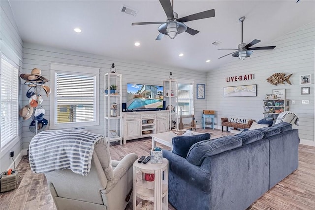 living area with lofted ceiling, light wood finished floors, visible vents, and recessed lighting