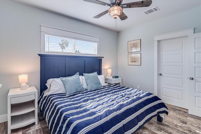 bedroom featuring ceiling fan, visible vents, and wood finished floors