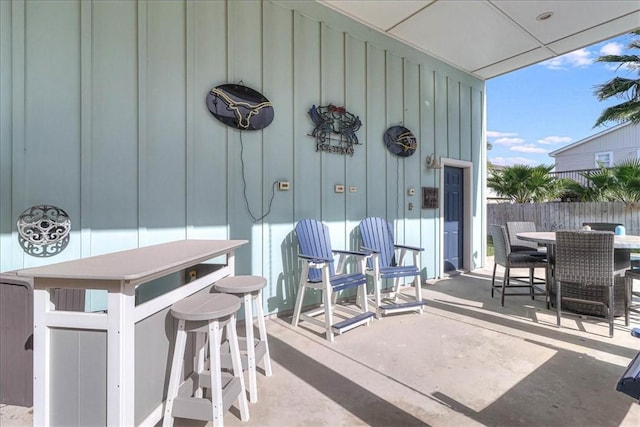 view of patio / terrace with outdoor dry bar, outdoor dining area, and fence