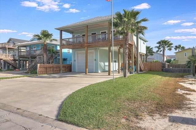 view of front of house with driveway, stairway, an attached garage, fence, and a front lawn