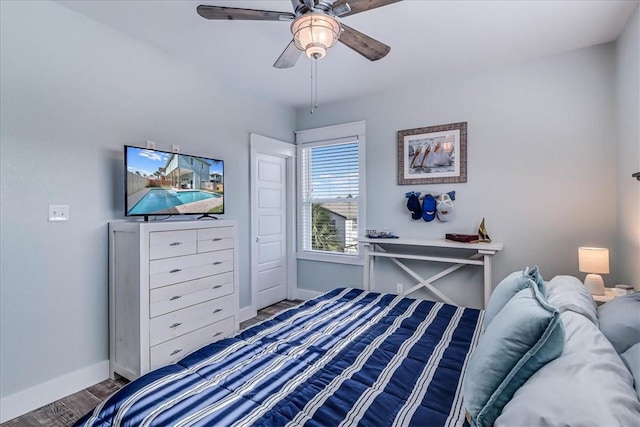 bedroom with wood finished floors, a ceiling fan, and baseboards