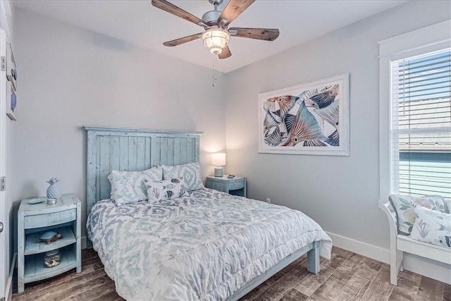 bedroom featuring ceiling fan, baseboards, and wood finished floors