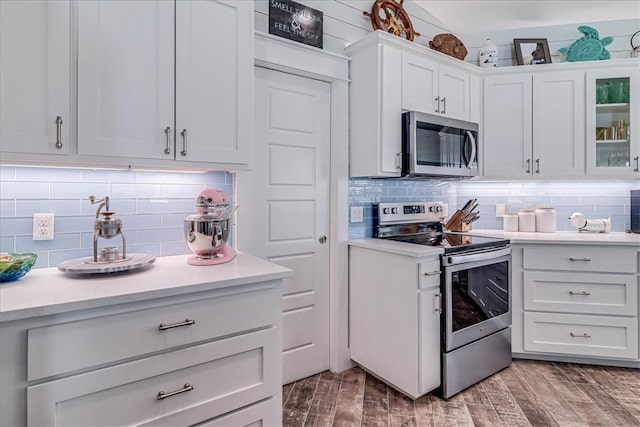 kitchen featuring appliances with stainless steel finishes, wood tiled floor, light countertops, and tasteful backsplash