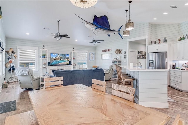 kitchen featuring white cabinetry, visible vents, stainless steel refrigerator with ice dispenser, and open floor plan