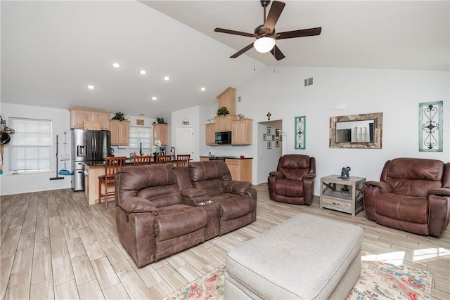 living room featuring plenty of natural light, ceiling fan, and light wood-type flooring