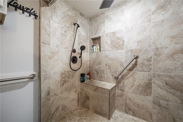 bathroom with visible vents and tiled shower