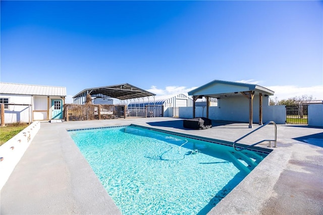 view of swimming pool featuring an outdoor structure, a patio area, fence private yard, and a fenced in pool