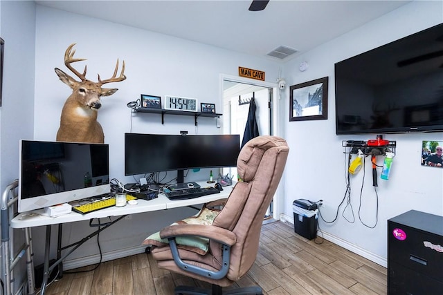 office area with wood finished floors, visible vents, and baseboards