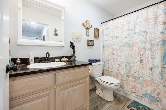 bathroom with toilet, a shower with curtain, wood finish floors, and vanity