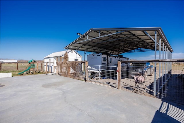 view of patio featuring a carport, a playground, and fence