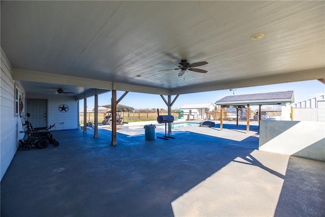 view of patio / terrace with a lanai, ceiling fan, fence, and a pool