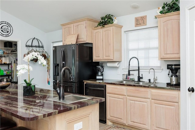 kitchen featuring dark stone countertops, sink, light brown cabinets, and black appliances