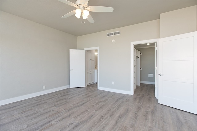 unfurnished bedroom with light wood-type flooring, ensuite bath, and ceiling fan