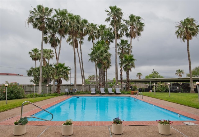 view of swimming pool featuring a yard