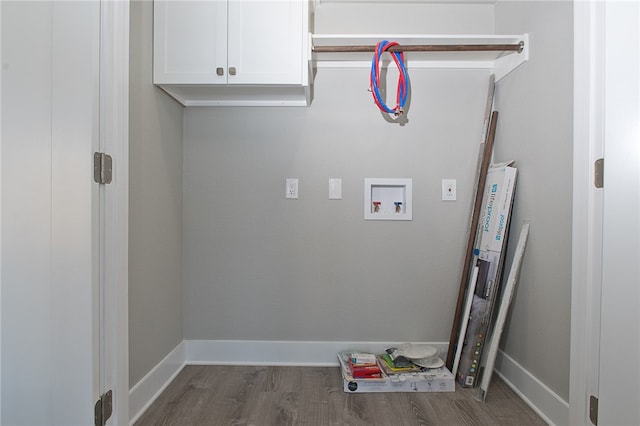 laundry room with dark hardwood / wood-style flooring, hookup for a washing machine, and cabinets