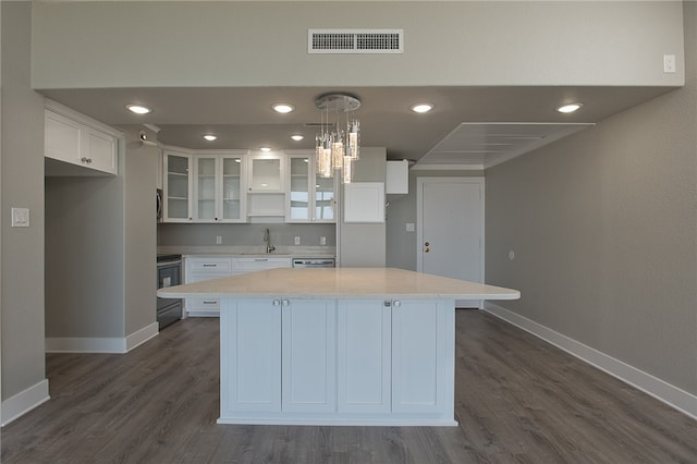 kitchen featuring white cabinets, dark hardwood / wood-style floors, pendant lighting, and a center island