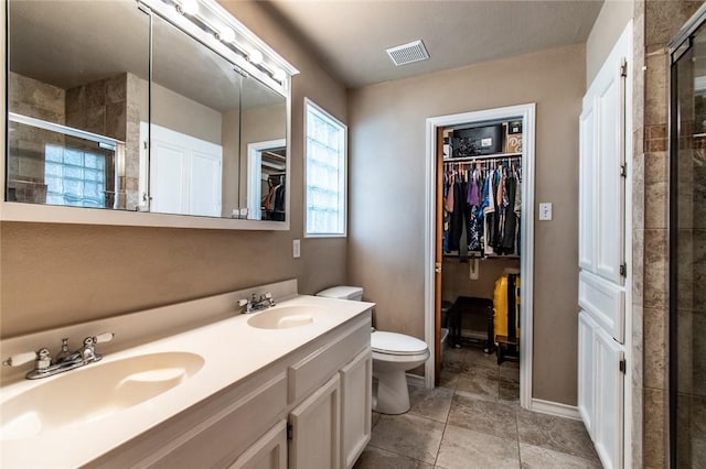 2725 Persimmon St, Corpus Christi, TX 78415 - full bathroom featuring a shower stall, double vanity, a walk in closet, and toilet
