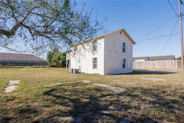 rear view of house with a lawn and central air condition unit