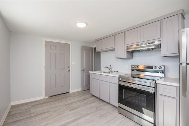 kitchen featuring light wood-type flooring, sink, and appliances with stainless steel finishes