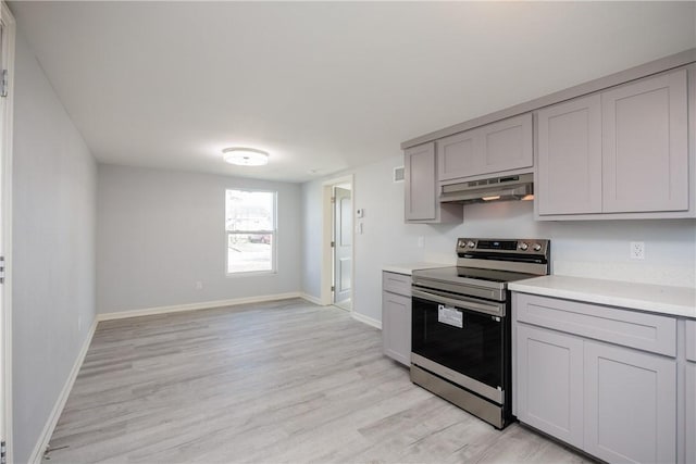 kitchen featuring gray cabinetry, light hardwood / wood-style floors, and stainless steel electric range