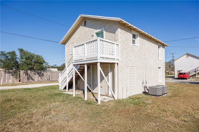 back of house featuring a wooden deck, a yard, and central AC