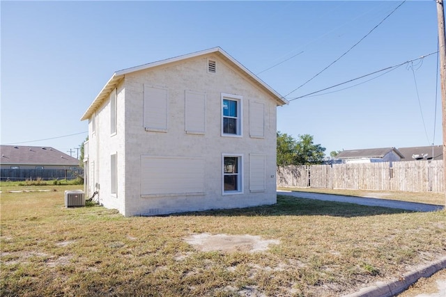 rear view of property with a lawn and central AC unit