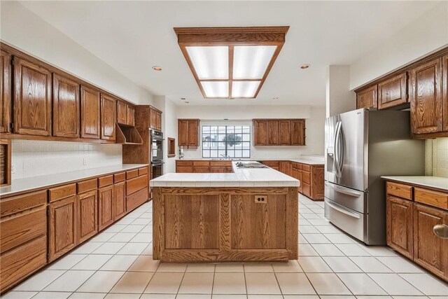 6714 Long Meadow Dr, Corpus Christi, TX 78413 - kitchen with appliances with stainless steel finishes, a kitchen island, light tile patterned flooring, and tile counters